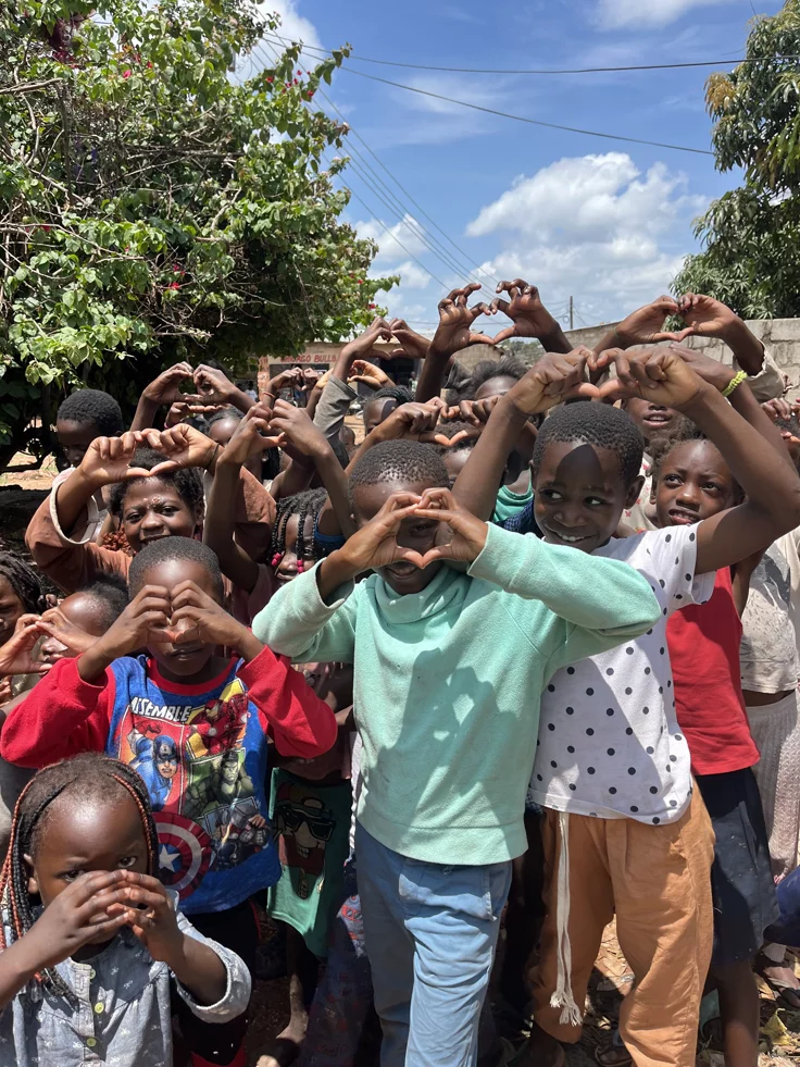 Children making heart signs outdoors