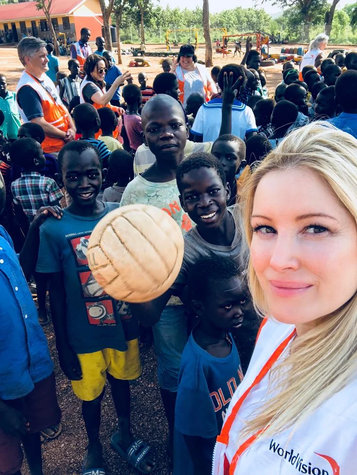 Volunteer with children in school uniforms
