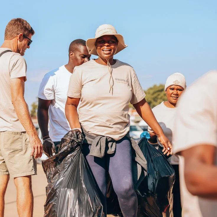 Adults doing community cleanup with bags