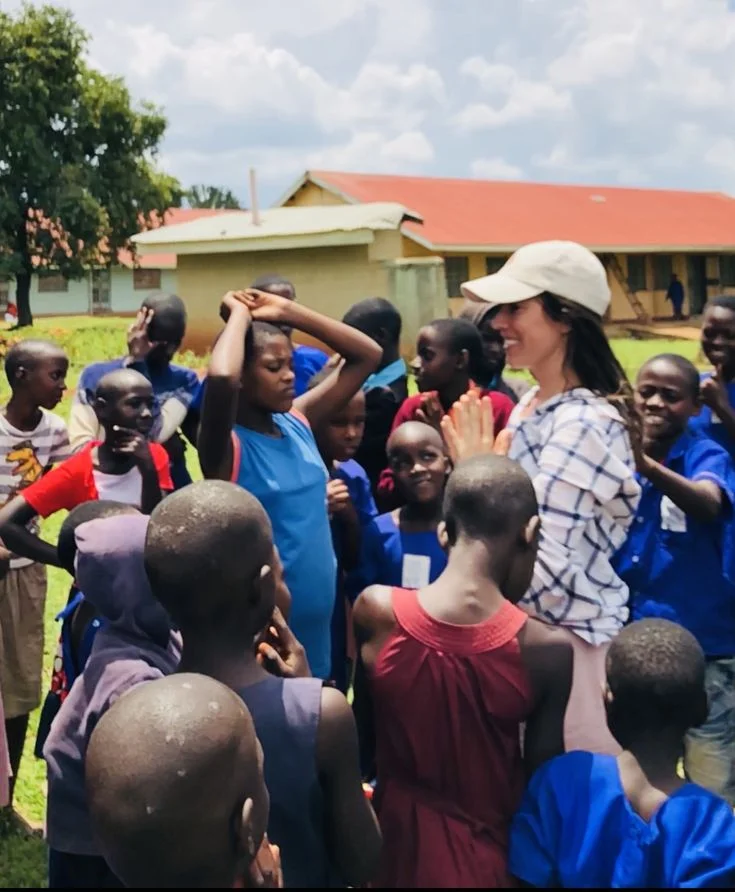 Female volunteer standing with community women and children