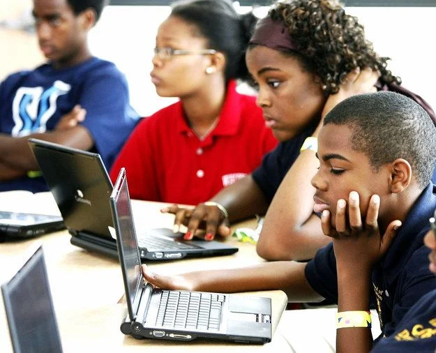 Girls working on laptops at training session